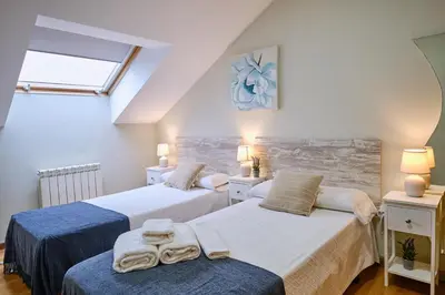 a bedroom with two beds with towels on them at Peregrina Pensión 2 in O Pedrouzo