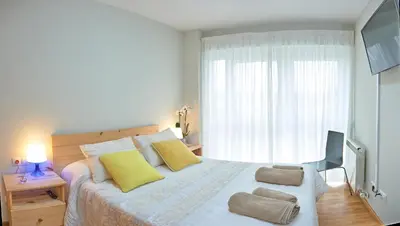 a bedroom with a bed with yellow pillows and a window at Peregrina Pensión 2 in O Pedrouzo