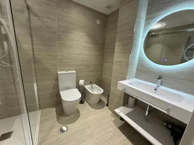 a bathroom with a toilet and a sink and a mirror at O recuncho in Monforte de Lemos
