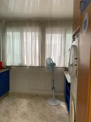 a kitchen with a fan in front of a window at O recuncho in Monforte de Lemos