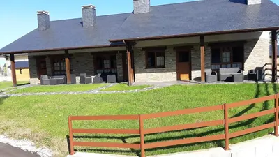 a house with a bench in front of it at Apartamentos Rurales Camín Real in La Caridad
