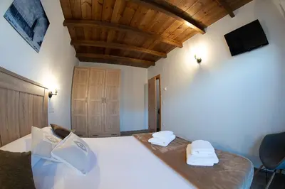 a bedroom with a bed with two towels on it at Apartamentos Rurales Camín Real in La Caridad