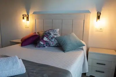a bedroom with a bed with pillows on it at Apartamentos Rurales Camín Real in La Caridad