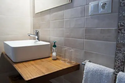 a bathroom with a white sink on a wooden counter at Apartamentos Rurales Camín Real in La Caridad