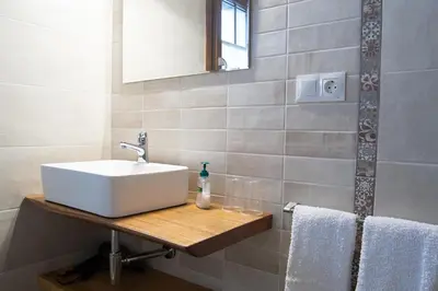 a bathroom with a sink and a mirror and towels at Apartamentos Rurales Camín Real in La Caridad