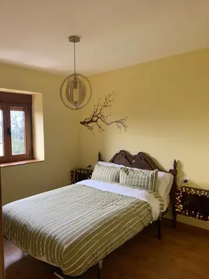 a bedroom with a bed with a white and black comforter at La casa de la valla azul (San Miguel de Langre) in San Miguel de Langre