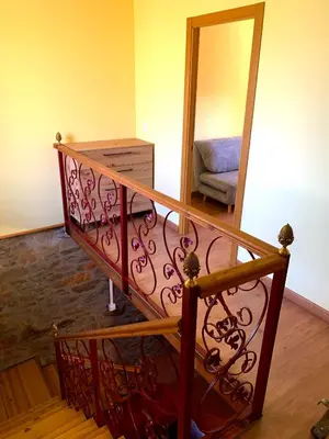 a spiral staircase in a living room with a couch at La casa de la valla azul (San Miguel de Langre) in San Miguel de Langre