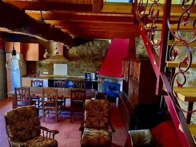a kitchen and dining room with a table and chairs at La casa de la valla azul (San Miguel de Langre) in San Miguel de Langre