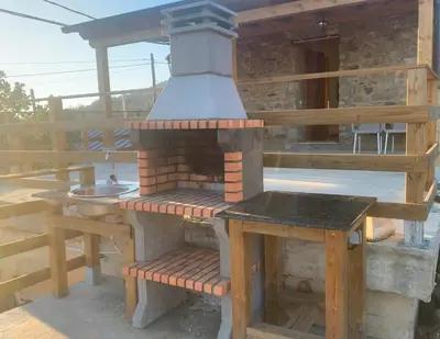 an outdoor kitchen with a stove on a deck at La casa de la valla azul (San Miguel de Langre) in San Miguel de Langre