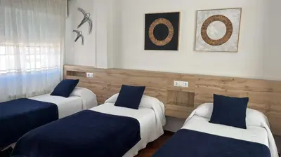 two beds in a room with blue and white at PR Una Estrella Dorada in O Pedrouzo
