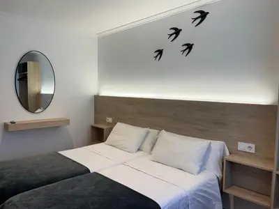 a bedroom with a bed with birds on the wall at PR Una Estrella Dorada in O Pedrouzo