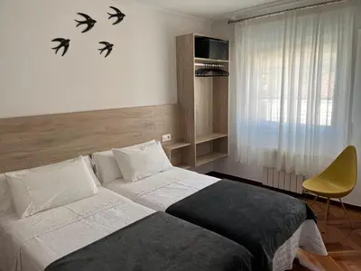a bedroom with a bed with birds on the wall at PR Una Estrella Dorada in O Pedrouzo
