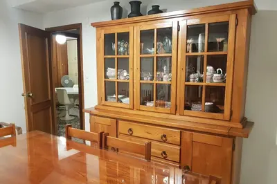 a wooden cabinet with china in a living room at Amplio y luminoso piso en el centro de Ourense in Ourense