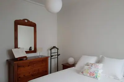 a bedroom with a bed with a dresser and a mirror at Amplio y luminoso piso en el centro de Ourense in Ourense