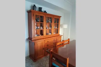 a wooden cabinet in a dining room with a table at Amplio y luminoso piso en el centro de Ourense in Ourense