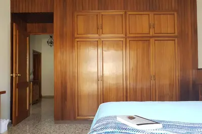 a bedroom with wooden cabinets and a bed with a book at Amplio y luminoso piso en el centro de Ourense in Ourense