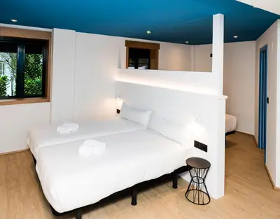 a bedroom with two beds and a blue ceiling at Alameda Rooms Santiago in Santiago de Compostela
