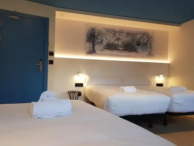 a bedroom with two beds with white sheets at Alameda Rooms Santiago in Santiago de Compostela