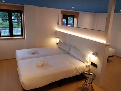 a bedroom with a bed with two towels on it at Alameda Rooms Santiago in Santiago de Compostela