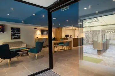 a view of a waiting room with chairs and a table at Alameda Rooms Santiago in Santiago de Compostela