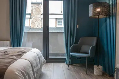 a bedroom with a bed and a chair and a window at Solarena Bistrot in Barreiros