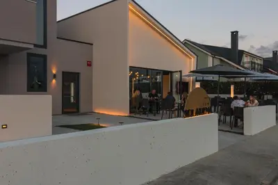 a building with a patio with people sitting at tables at Solarena Bistrot in Barreiros