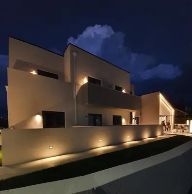 a large white house with lights on it at night at Solarena Bistrot in Barreiros