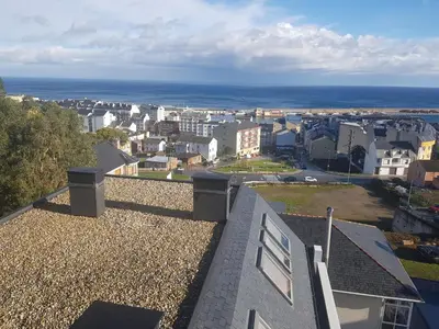 a view of a city from the roof of a house at Apartamentos Burela in Burela de Cabo