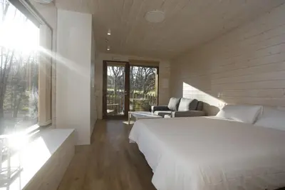 a bedroom with a large white bed and a couch at Cabanas das Chousas in Lugo
