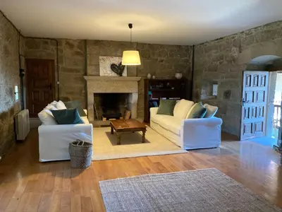 a living room with two white couches and a fireplace at Pazo de San Pedro de Bembibre in Taboada
