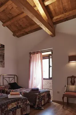 a dining room and living room with wooden ceilings at Parga Natura Alojamiento in Parga
