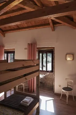 a room with a bed and a chair in it at Parga Natura Alojamiento in Parga