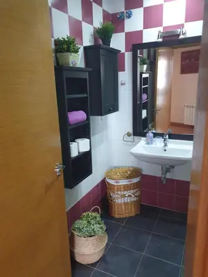 a bathroom with a sink and a mirror and a basket at Apartamento Ático Cine Colón in Ribadeo