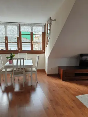 a dining room with a table and chairs and a tv at Apartamento Ático Cine Colón in Ribadeo