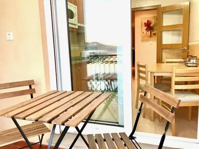 a wooden bench sitting next to a table and a balcony at Marina Sol te hará soñar in Vivero
