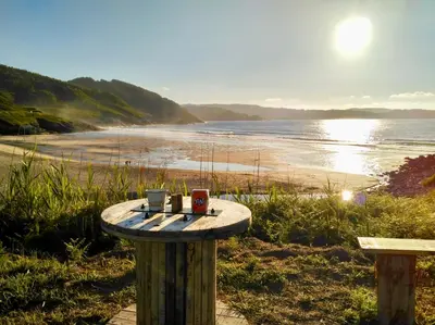 a table on the beach with two coffee mugs at Marina Sol te hará soñar in Vivero