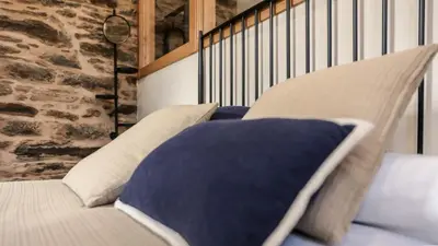 a bedroom with a bed with pillows and a brick wall at Casa da Marquesa Sarria in Sarria
