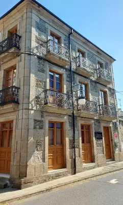 a stone building with windows and balconies on a street at Casa da Marquesa Sarria in Sarria