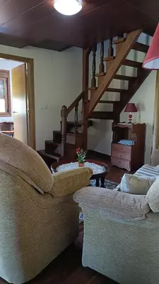 a living room with a couch and a spiral staircase at Casa Quintela in Ourense