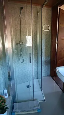 a shower with a glass door next to a sink at Casa Quintela in Ourense