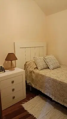 a bedroom with a bed and a dresser with a lamp at Casa Quintela in Ourense