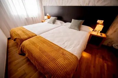 a bedroom with a large bed with a yellow blanket at Noja rooms 1 in O Pedrouzo