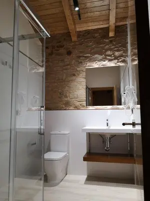 a bathroom with a sink and a toilet and a mirror at Casa Rural Camino Real in Melide