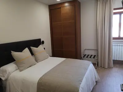 a bedroom with a large bed with white sheets and pillows at Casa Rural Camino Real in Melide