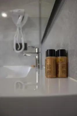 two bottles of medicines sitting on a bathroom sink at Casa Rural Camino Real in Melide