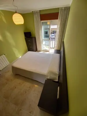 a bedroom with a white bed and a window at Piso completo en Camiño Inglés - Sigüeiro, in Sigüeiro