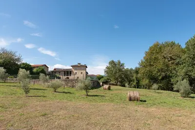 a field with hay bales in front of a house at Pazo de Moreda in Sober