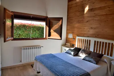 a bedroom with a blue bed and a window at Lares · Cabañas Rurales in Las Médulas