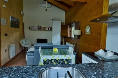 a kitchen and living room with a couch and a table at Lares · Cabañas Rurales in Las Médulas