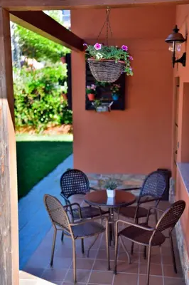 a patio with a table and chairs and a hanging basket at Lares · Cabañas Rurales in Las Médulas